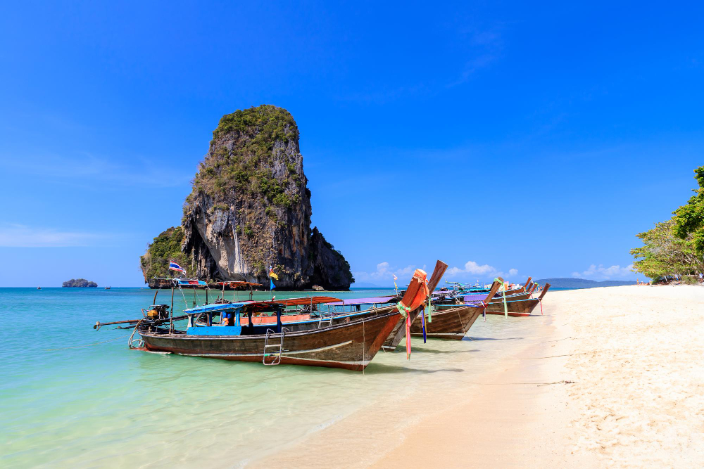 long-tail-boat-turquoise-crystal-clear-sea-water-with-limestone-cliff-mountain-phra-nang-beach-krabi-thailand
